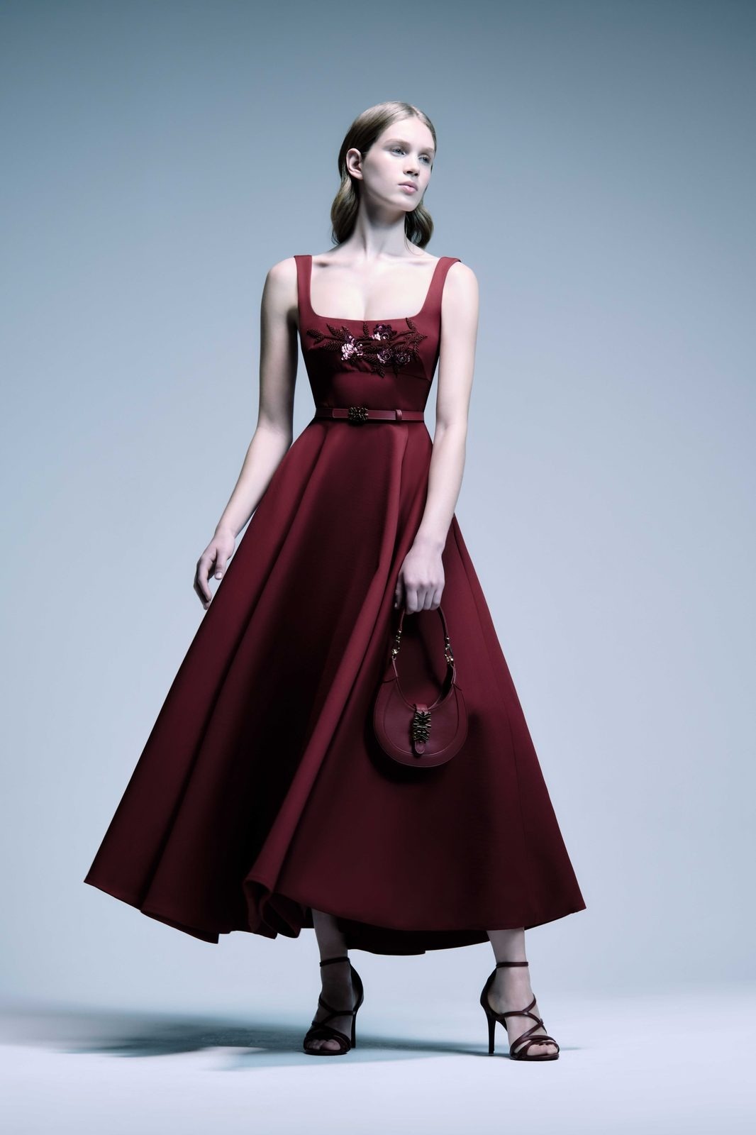 Modella Zuhair Murad in abito lungo bordeaux con borsa a mano coordinata