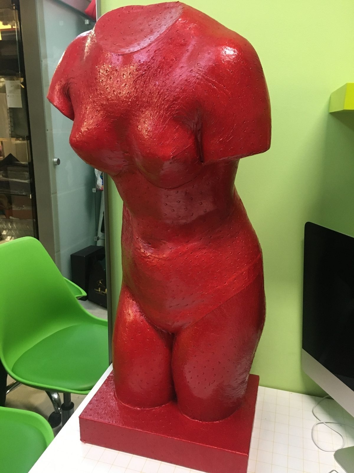 Scultura di un busto rivestita in pelle di struzzo rossa